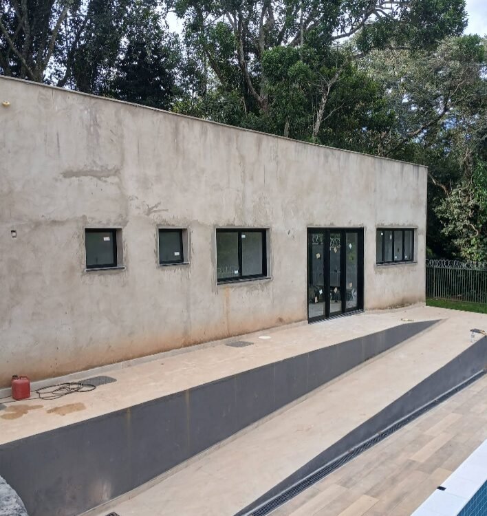 Janelas de vidro em fachada com área de piscina